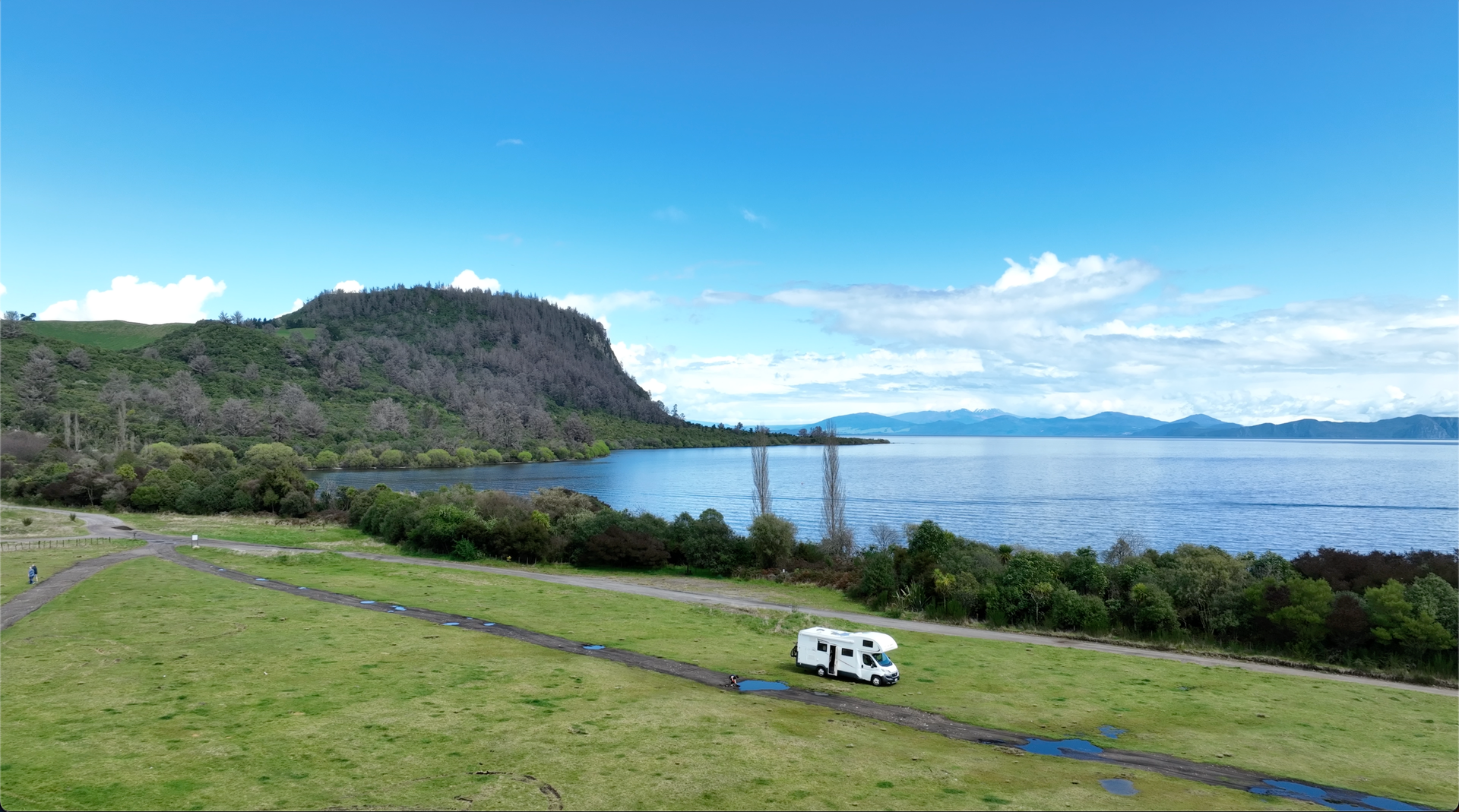 Campervan parked on the lawn at Whakaipō Bay Recreational Reserve with view over Lake Taupo